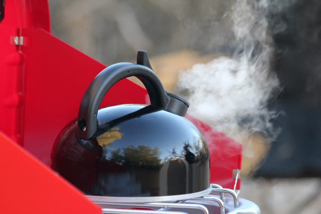 A two-burner camp stove set up for cooking outdoors