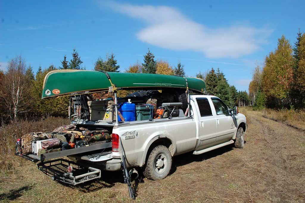 A cooler loaded with ice and drinks at a campsite