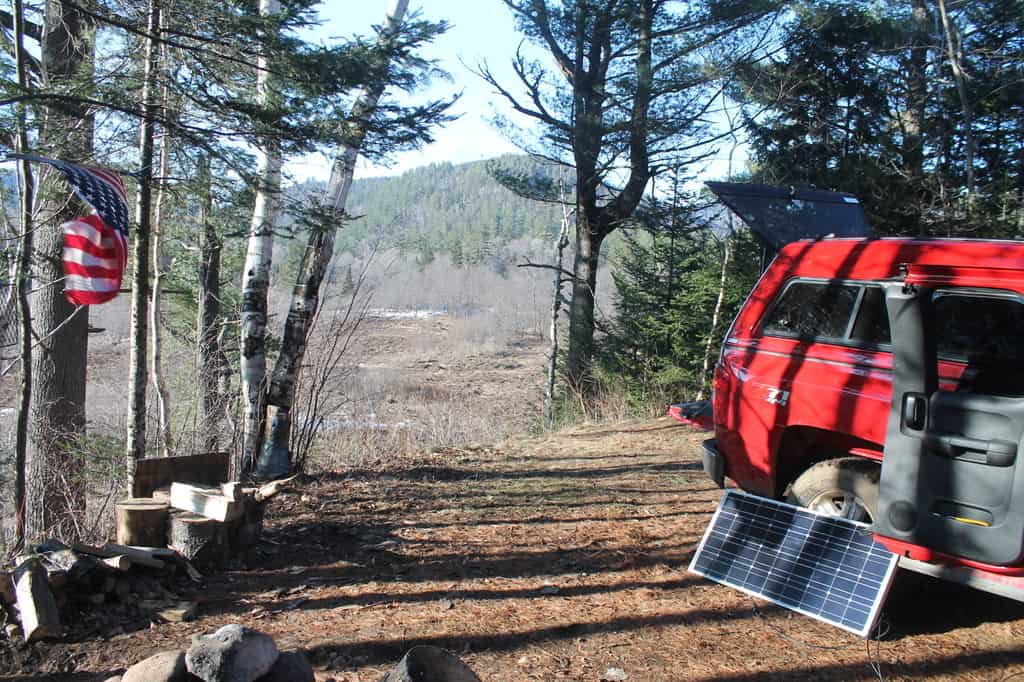 A portable power station and solar panel at a campsite