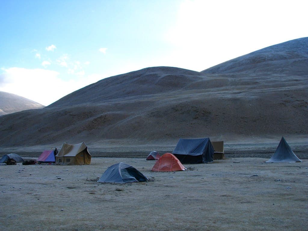Frost on the ground beside a tent at sunrise
