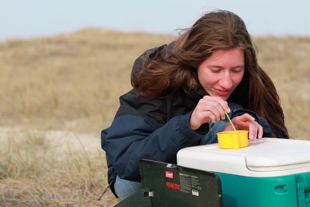 A hard cooler outdoors with drinks and ice
