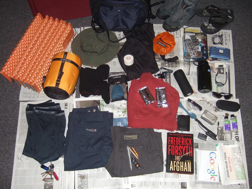 Backpacking gear laid out on the floor before packing